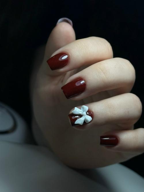 Элегантный бордовый маникюр с изящным белым бантиком на одном из ногтей - сочетание классики и игривости! 01